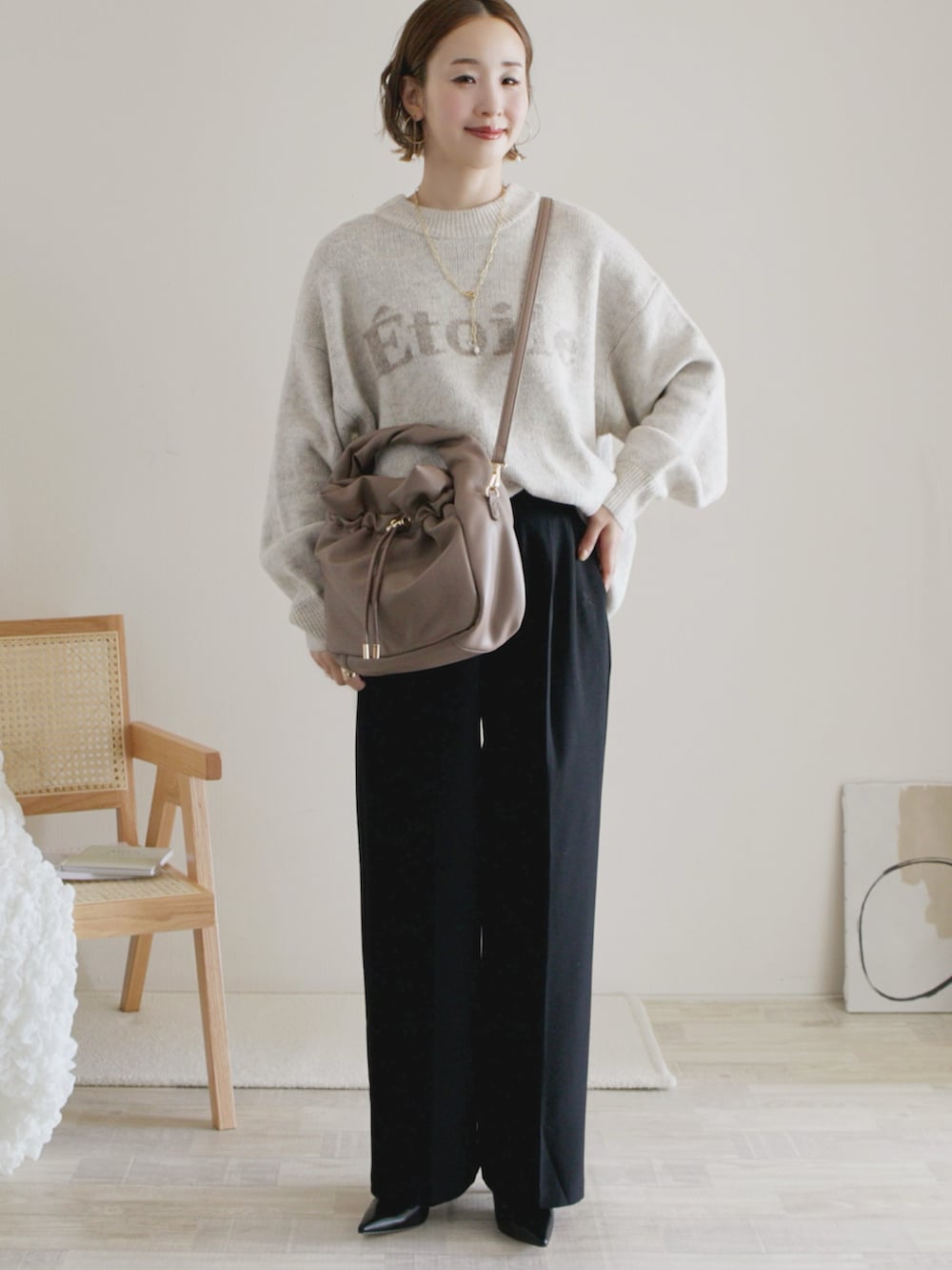 ブラック系のワンピース、ホワイト系のトップス、ブラック系のパンプスを着用したレディースの秋コーディネートの4枚目の写真