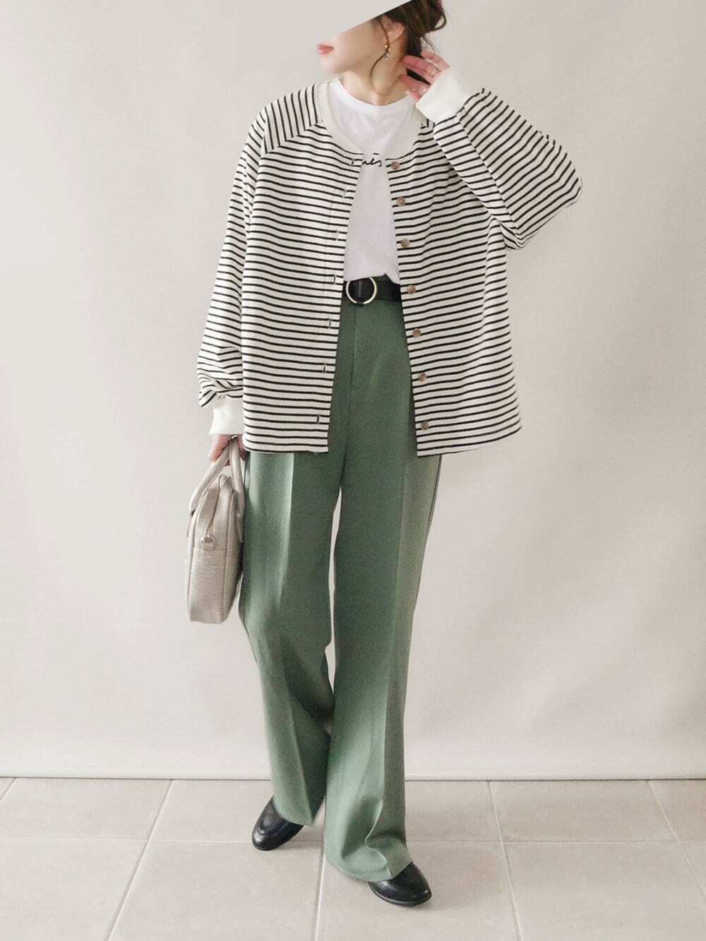 ホワイト系のトップス、グリーン系のパンツ、ベージュ系のショルダーバッグを着用したレディースの冬コーディネートの3枚目の写真