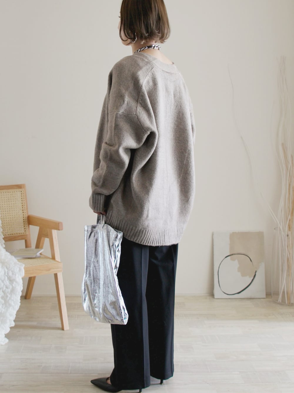 ベージュ系のカーディガン/ボレロ、ブラック系のパンツ、シルバー系のエコバッグ/サブバッグを着用したレディースの秋コーディネートの3枚目の写真