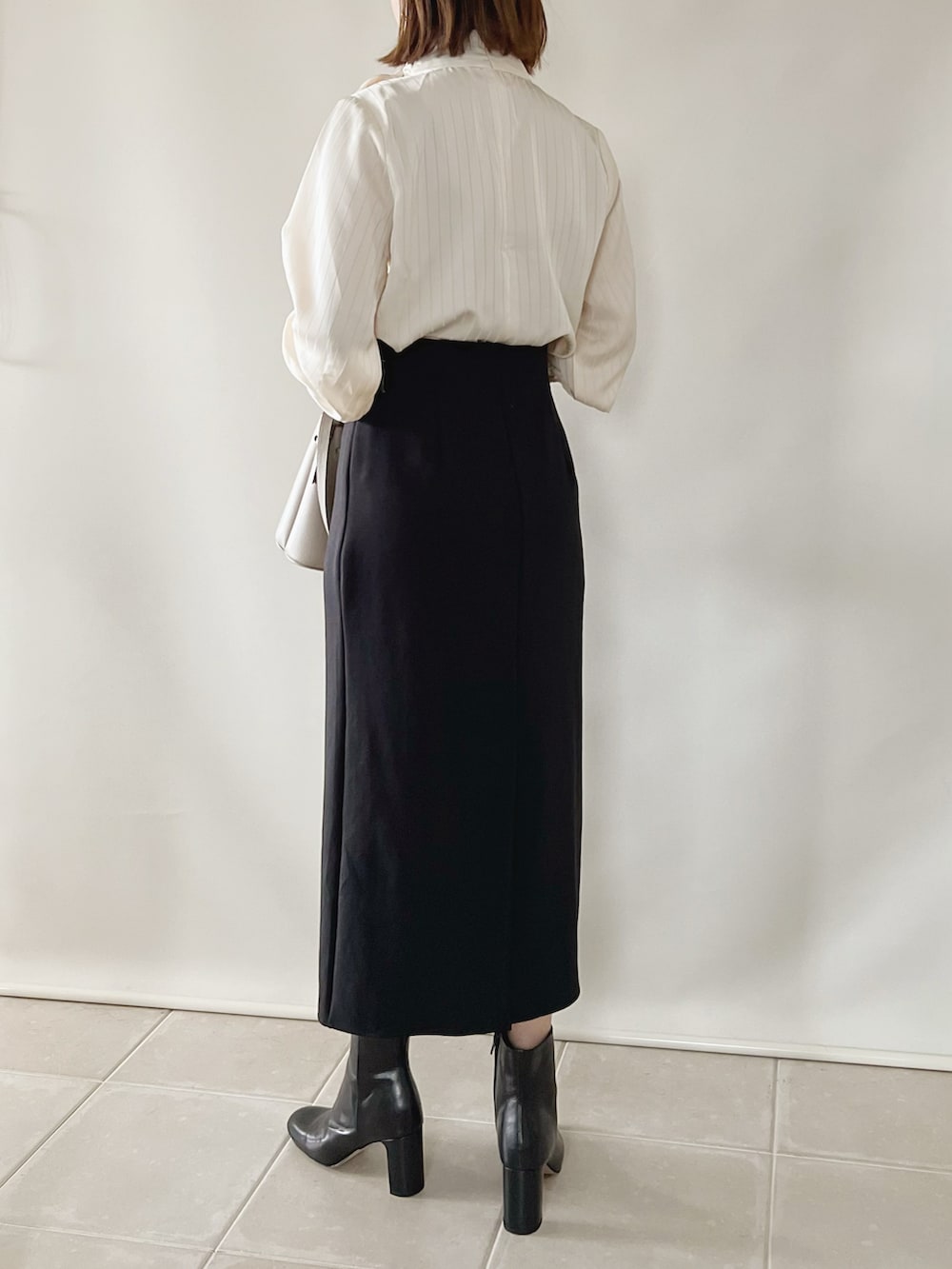 ホワイト系のシャツ/ブラウス、ブラック系のスカート、グレー系のバッグを着用したレディースの夏コーディネートの2枚目の写真