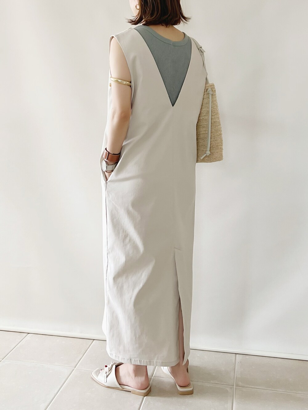 ベージュ系のジャンパースカート、グリーン系のトップス、ホワイト系のシューズを着用したレディースの夏コーディネートの2枚目の写真