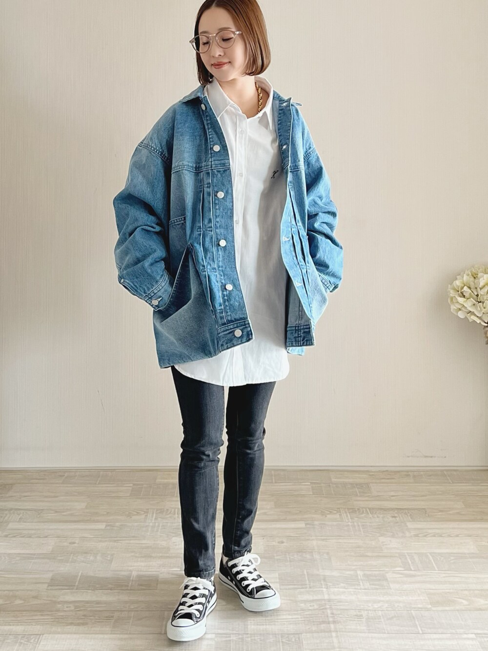 ブルー系のデニムジャケット、ホワイト系のトップス、ブラック系のパンツを着用したレディースの冬コーディネートの2枚目の写真