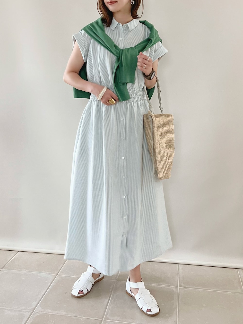 グリーン系のワンピース、グリーン系のトップス、ベージュ系のショルダーバッグを着用したレディースの春コーディネートの2枚目の写真