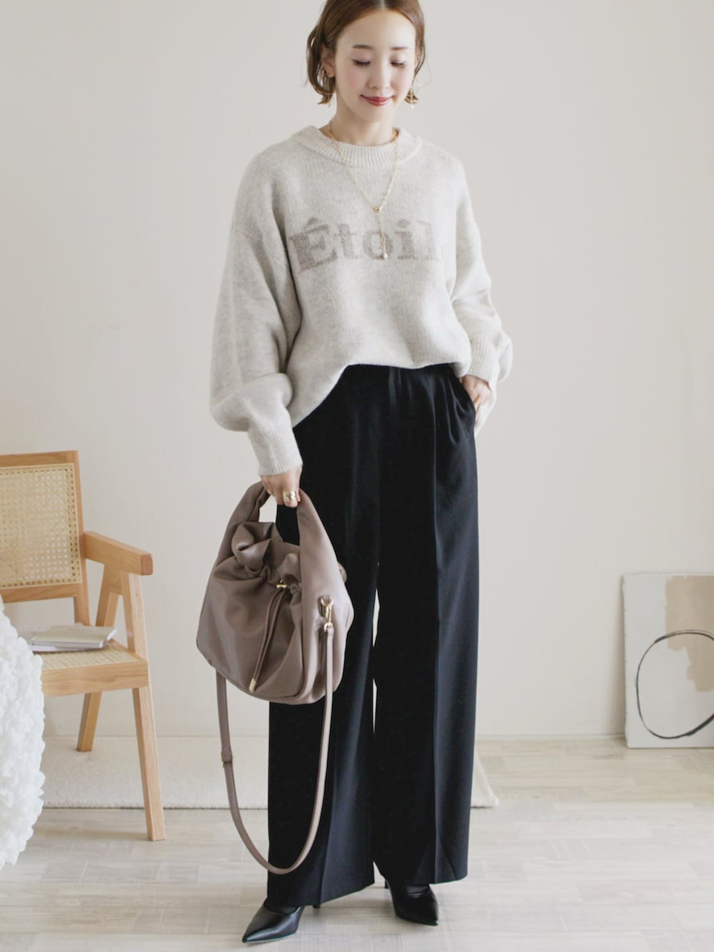 ブラック系のワンピース、ホワイト系のトップス、ブラック系のパンプスを着用したレディースの秋コーディネートの3枚目の写真