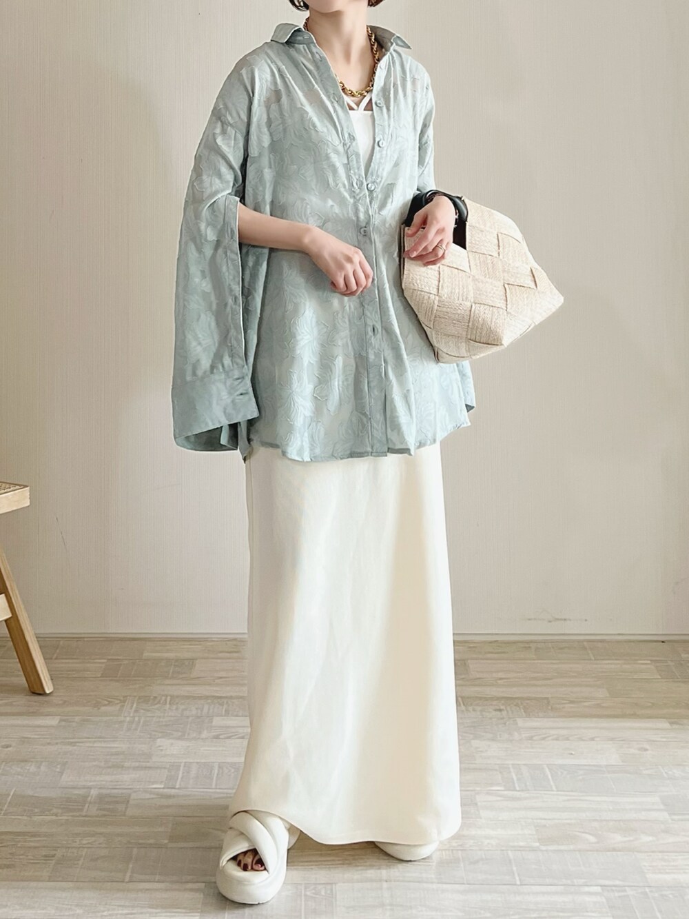 グリーン系のシャツ/ブラウス、ホワイト系のスカート、ベージュ系のバッグを着用したレディースの春コーディネートの2枚目の写真