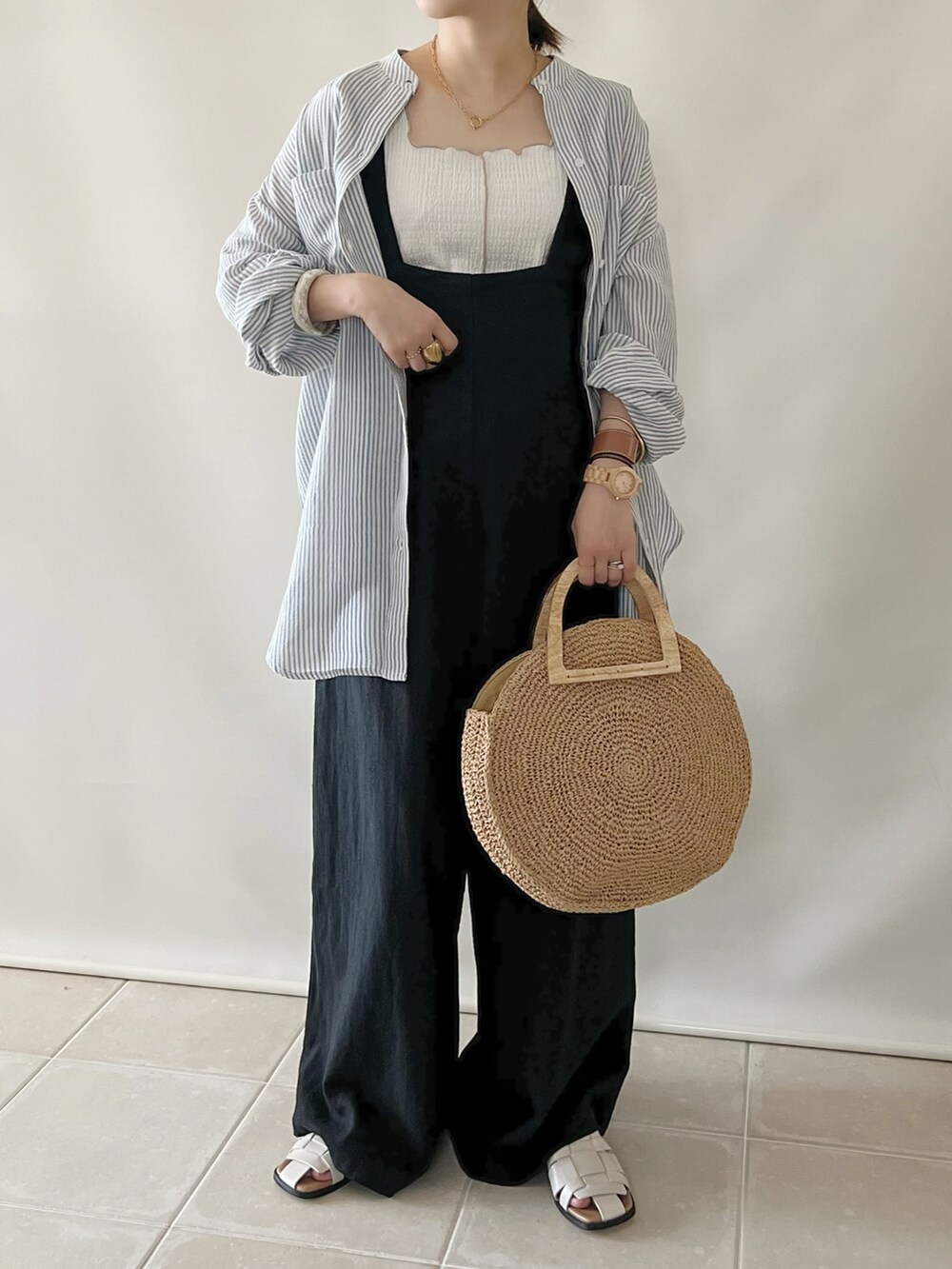 ブルー系のシャツ/ブラウス、ブラック系のサロペット/オーバーオール、ベージュ系のアナログ腕時計を着用したレディースの夏コーディネートの2枚目の写真