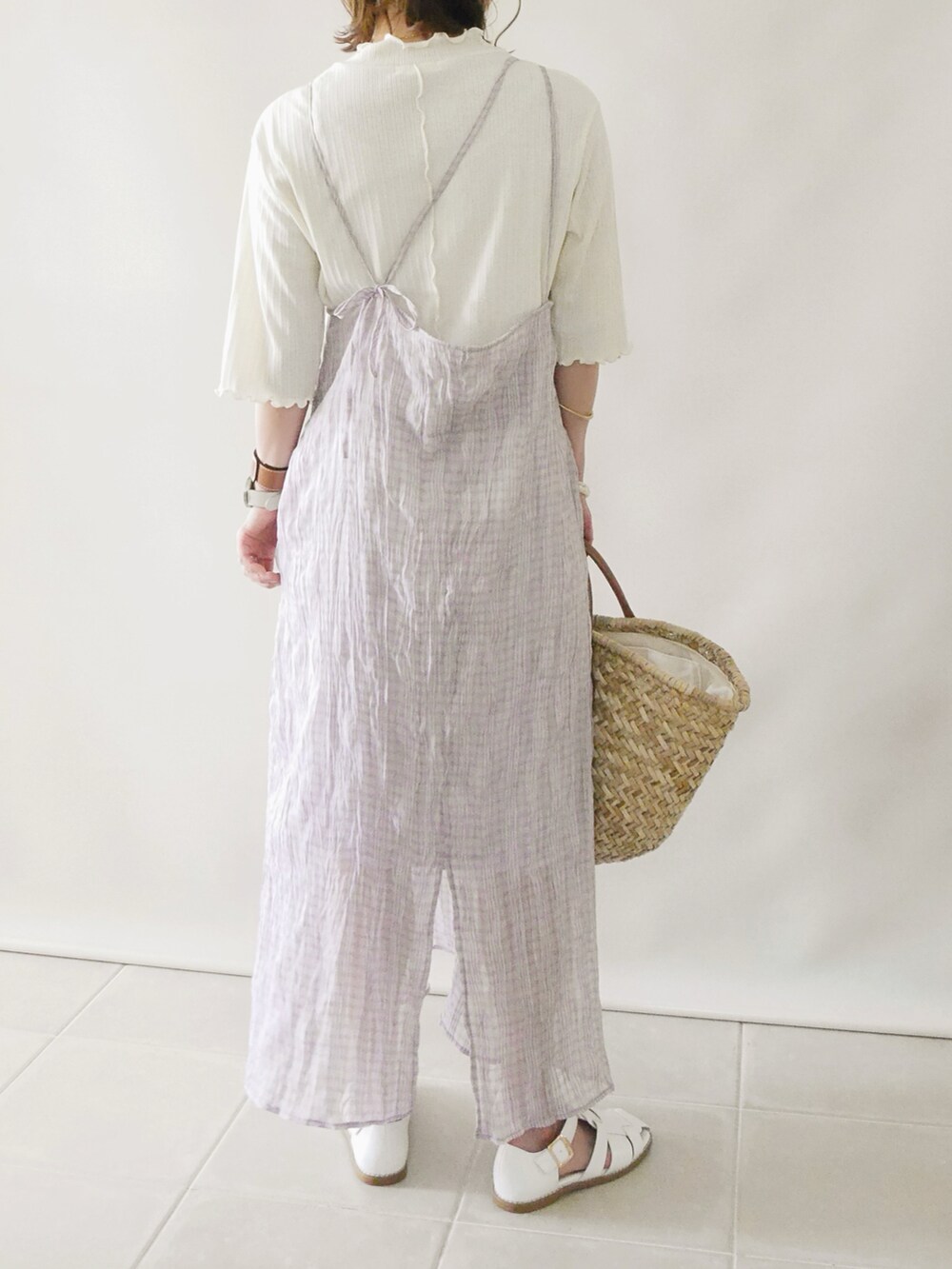 パープル系のワンピース、ホワイト系のトップス、ベージュ系のバッグを着用したレディースの春コーディネートの2枚目の写真