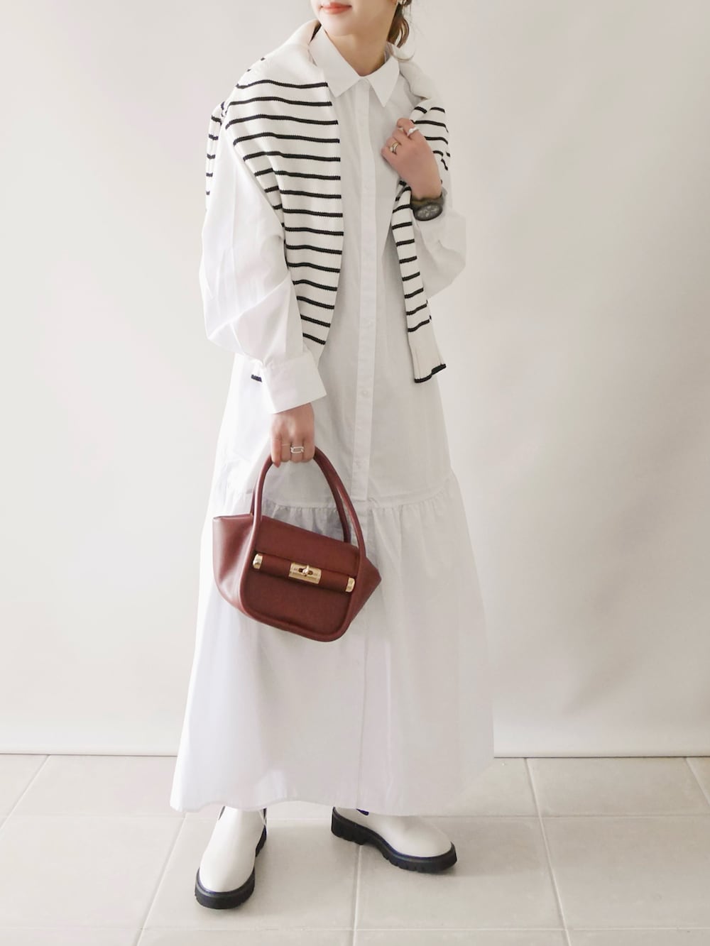 ホワイト系のワンピース/ドレス、ホワイト系のトップス、ブラウン系のバッグを着用したレディースの冬コーディネートの2枚目の写真