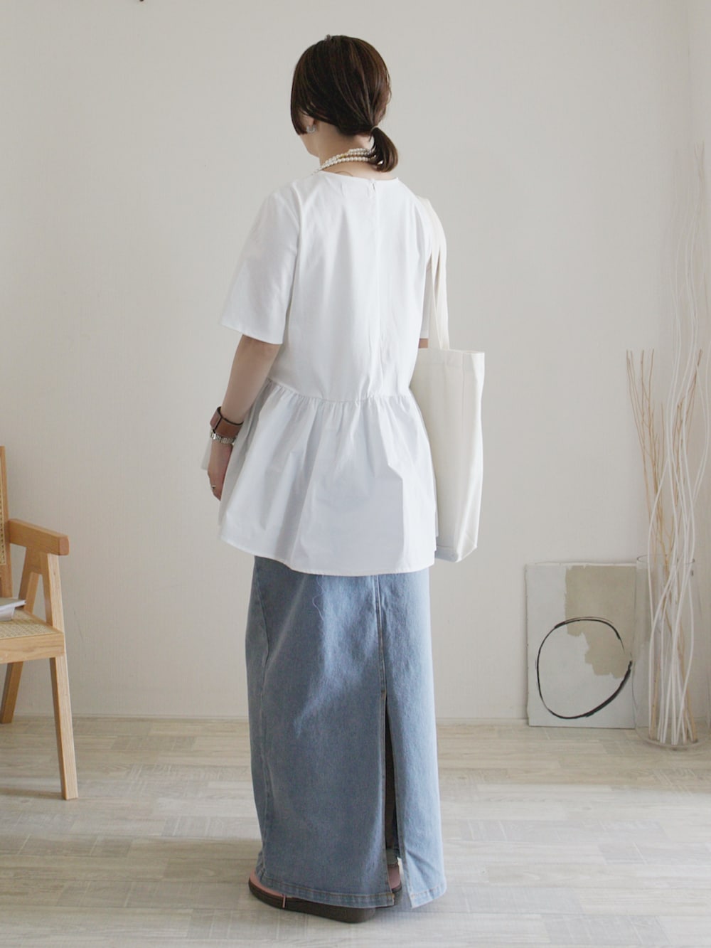 ホワイト系のTシャツ/カットソー、ブルー系のデニムスカート、ピンク系のスニーカーを着用したレディースの春コーディネートの3枚目の写真