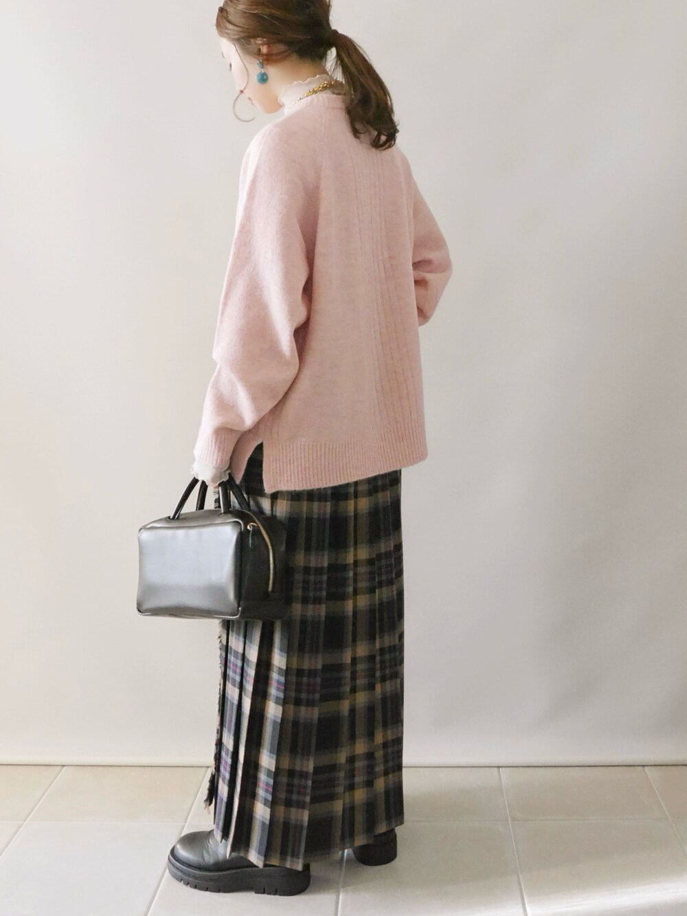 ピンク系のニット/セーター、ブラック系のその他パンツ、ブラック系のボストンバッグを着用したレディースの冬コーディネートの4枚目の写真