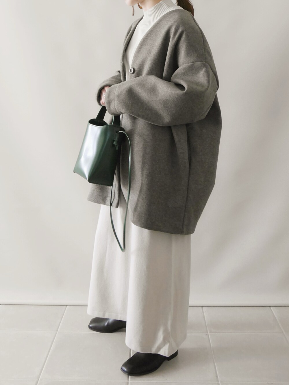 ベージュ系のワンピース/ドレス、グリーン系のショルダーバッグ、ブラック系のシューズを着用したレディースの秋コーディネートの3枚目の写真