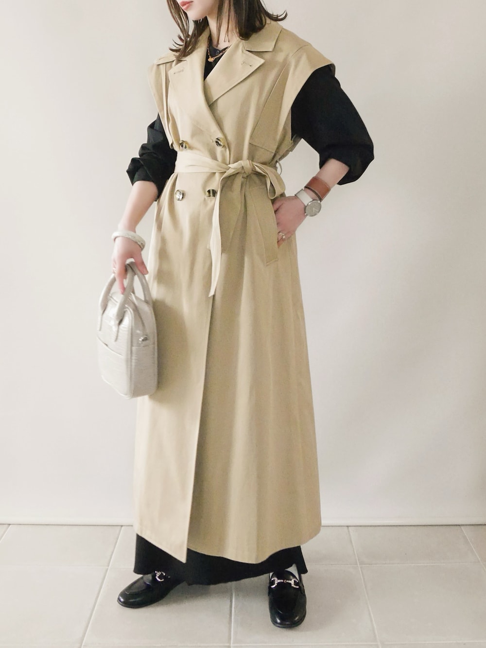 ベージュ系のトレンチコート、ブラック系のシャツ/ブラウス、ブラック系のスカートを着用したレディースの春コーディネートの3枚目の写真