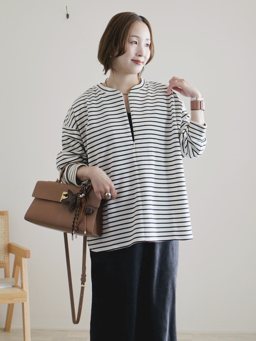 ホワイト系のTシャツ/カットソー、ブラック系のスカート、ブラック系のスニーカーを着用したレディースの春コーディネートの3枚目の写真