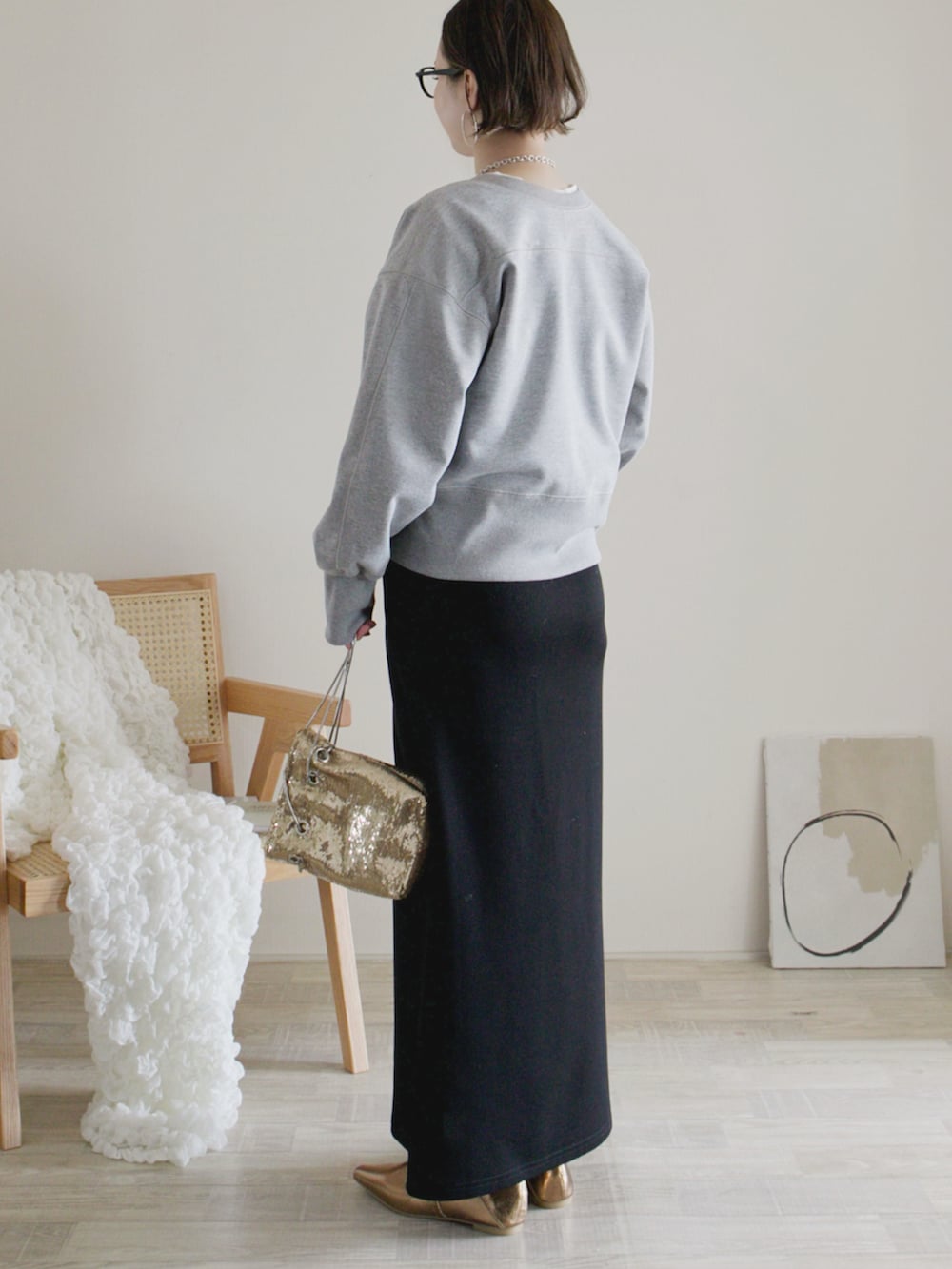 グレー系のカーディガン/ボレロ、ブラック系のスカート、ゴールド系のパンプスを着用したレディースの春コーディネートの2枚目の写真