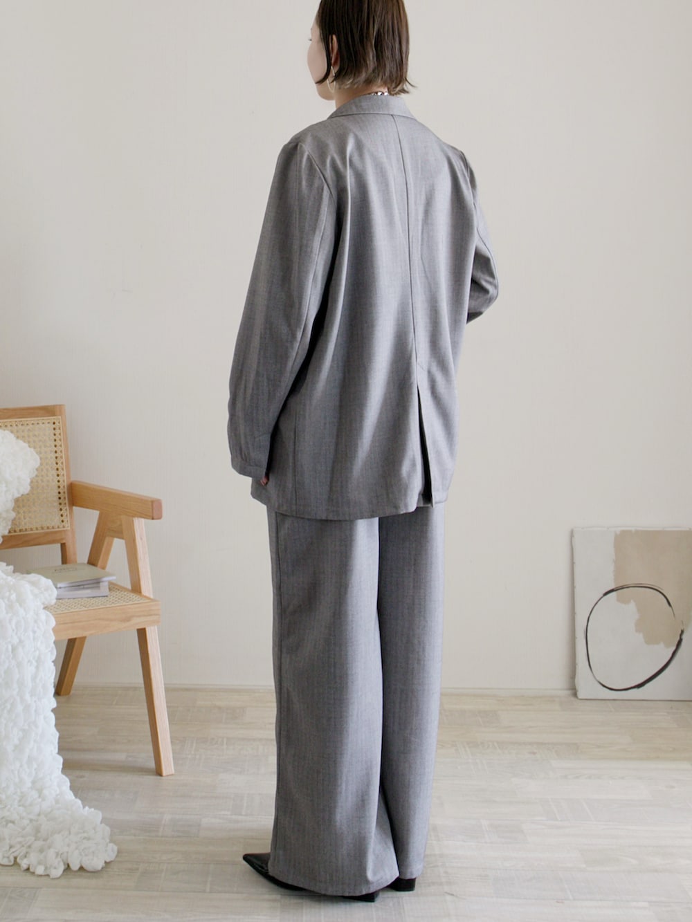 グレー系のテーラードジャケット、グレー系のワンピース、ブラック系のパンプスを着用したレディースの冬コーディネートの3枚目の写真