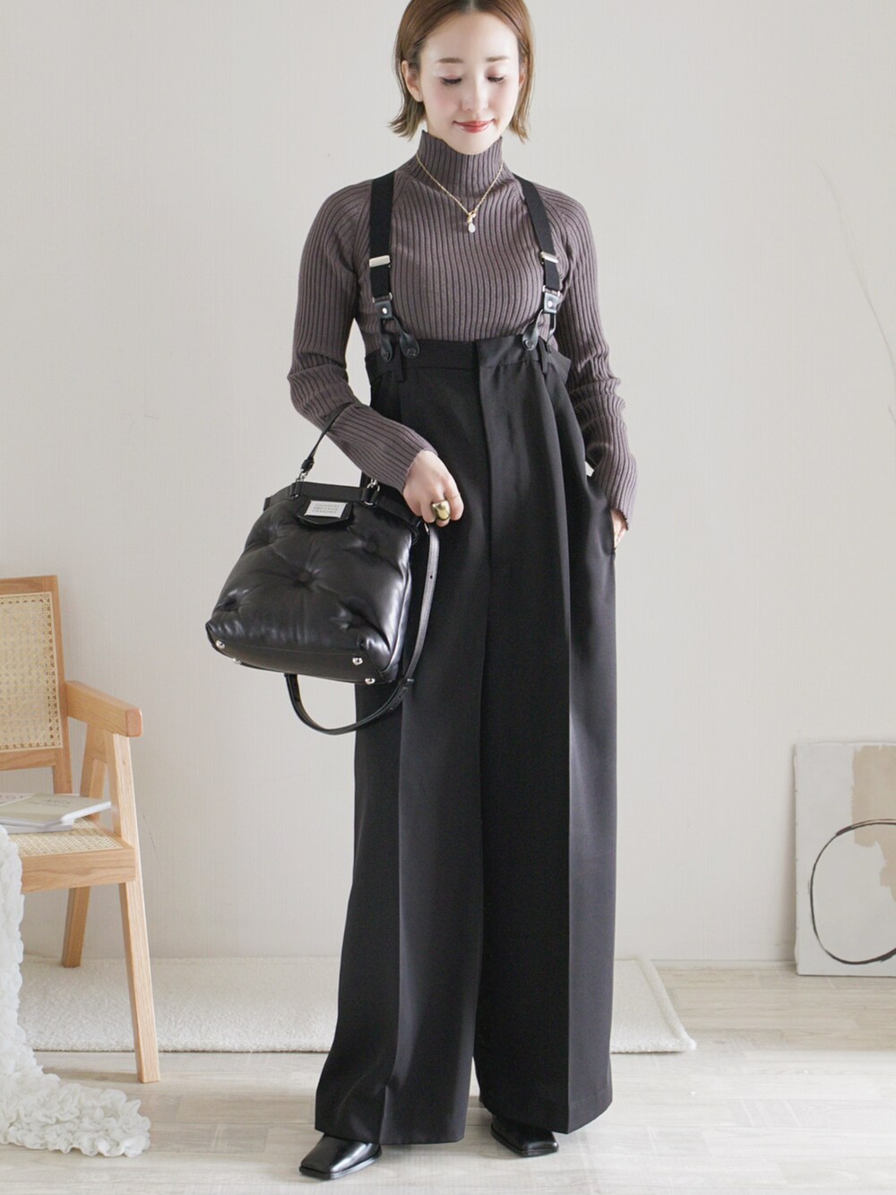 グレー系のニット/セーター、ブラック系のその他パンツ、ブラック系のショルダーバッグを着用したレディースの秋コーディネートの3枚目の写真