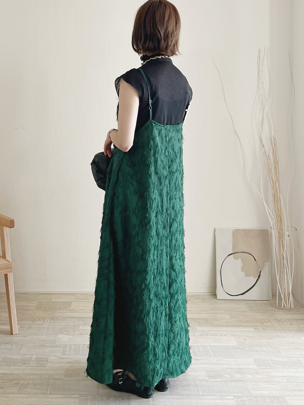 グリーン系のワンピース、ブラック系のTシャツ/カットソー、ブラック系のパンプスを着用したレディースの秋コーディネートの2枚目の写真