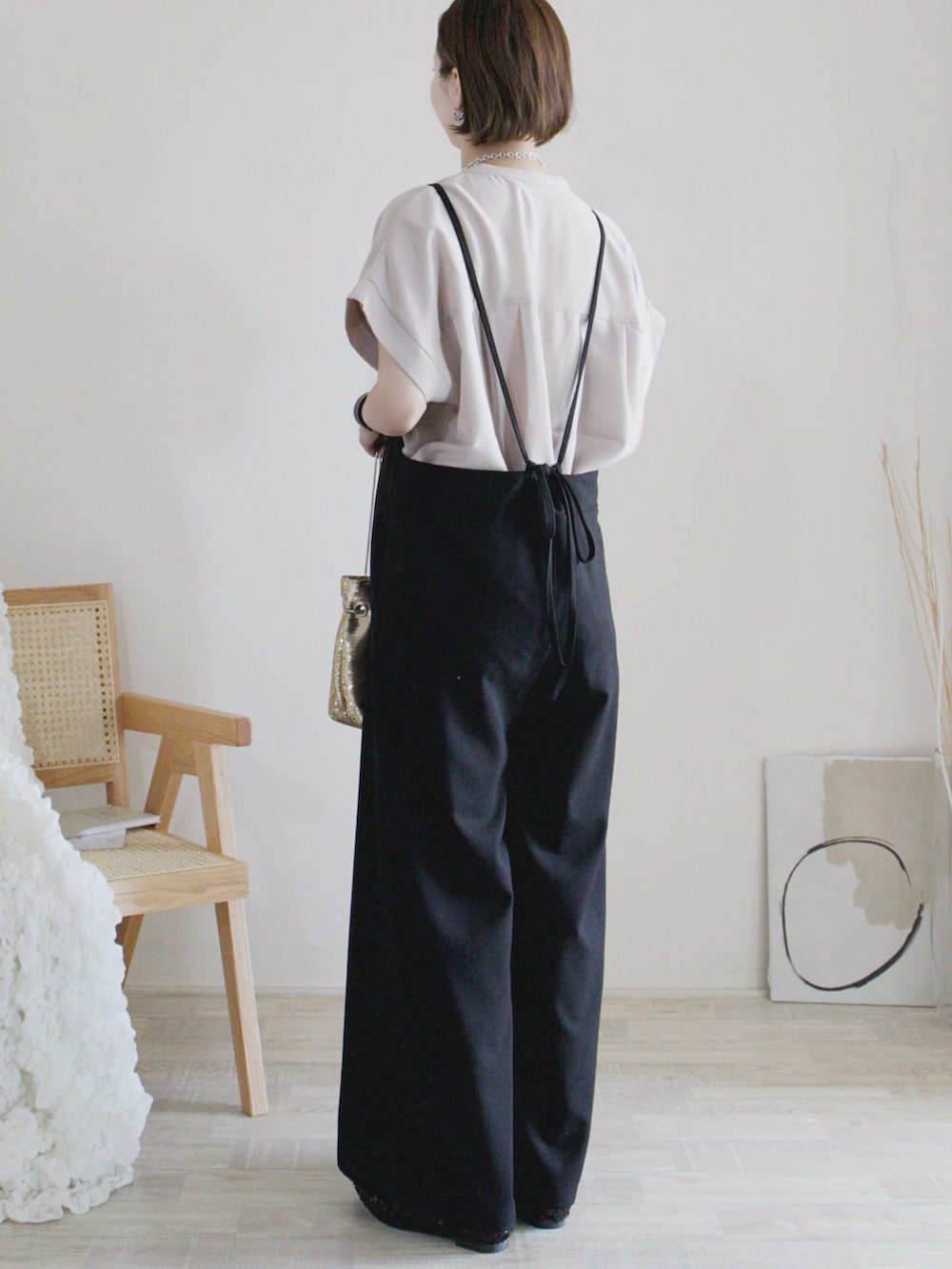 ブラック系のワンピース、グレー系のシャツ/ブラウス、ゴールド系のハンドバッグを着用したレディースの春コーディネートの2枚目の写真