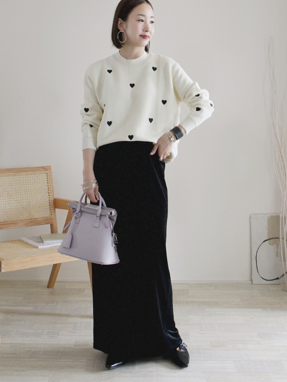 ブラック系のスカート、ホワイト系のニット/セーター、ブラック系のパンプスを着用したレディースの秋コーディネートの2枚目の写真