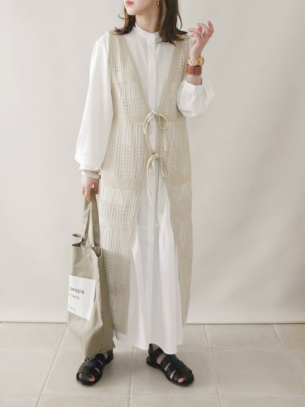 ベージュ系のニット/セーター、ベージュ系のワンピース、ブラック系のサンダルを着用したレディースの春コーディネートの5枚目の写真