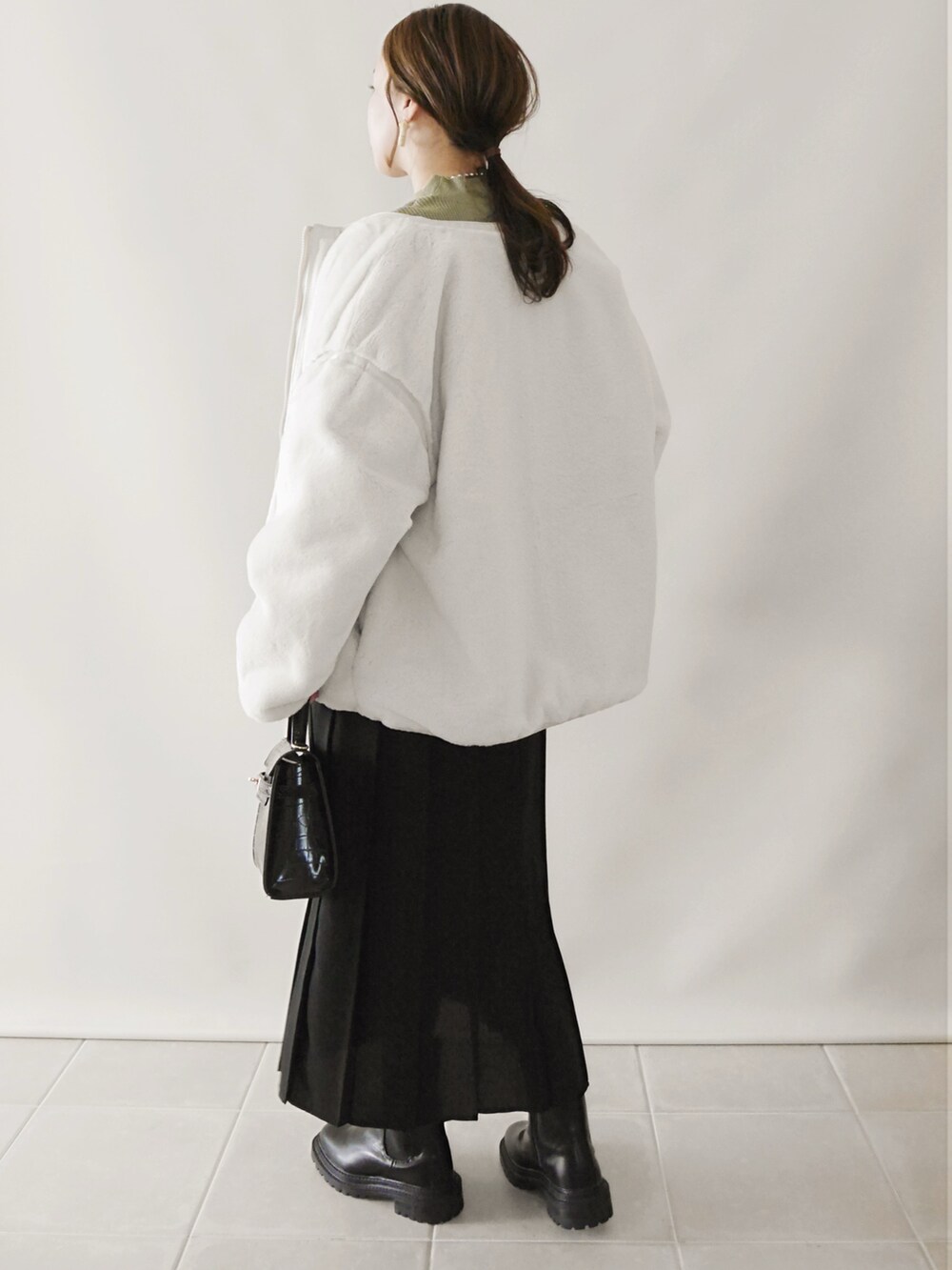 ベージュ系のブルゾン、ブラック系のスカート、ブラック系のショルダーバッグを着用したレディースの秋コーディネートの2枚目の写真