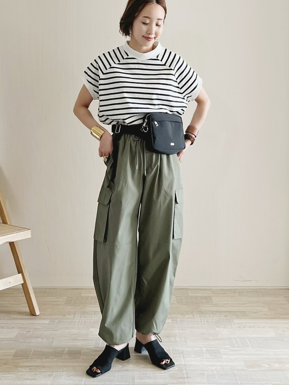 ブラック系のボディバッグ/ウエストポーチ、その他のTシャツ/カットソー、グリーン系のデニムパンツを着用したレディースの春コーディネートの2枚目の写真