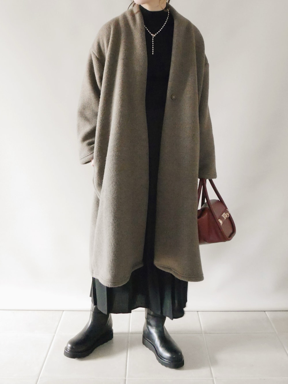 ブラウン系のその他アウター、ブラック系のトップス、ブラック系のスカートを着用したレディースの冬コーディネートの2枚目の写真