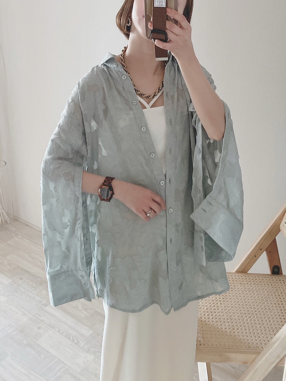 グリーン系のシャツ/ブラウス、ホワイト系のスカート、ベージュ系のバッグを着用したレディースの春コーディネートの4枚目の写真