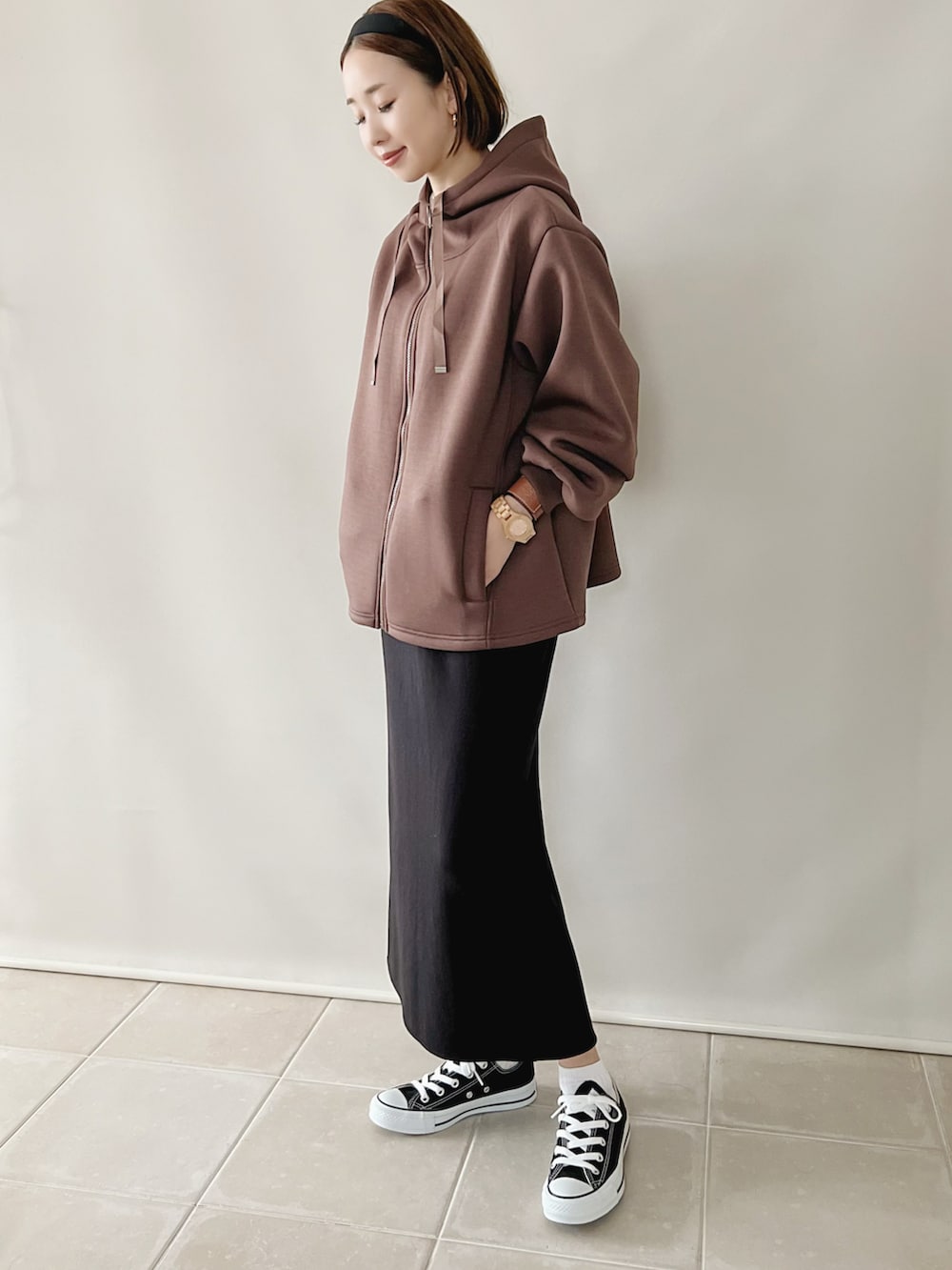 ブラウン系のジャケット/アウター、ホワイト系のトップス、ブラック系のスカートを着用したレディースの秋コーディネートの3枚目の写真