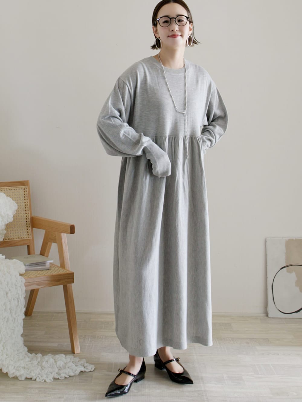 グレー系のワンピース、ホワイト系のパンプス、シルバー系のバングル/リストバンドを着用したレディースの冬コーディネートの4枚目の写真