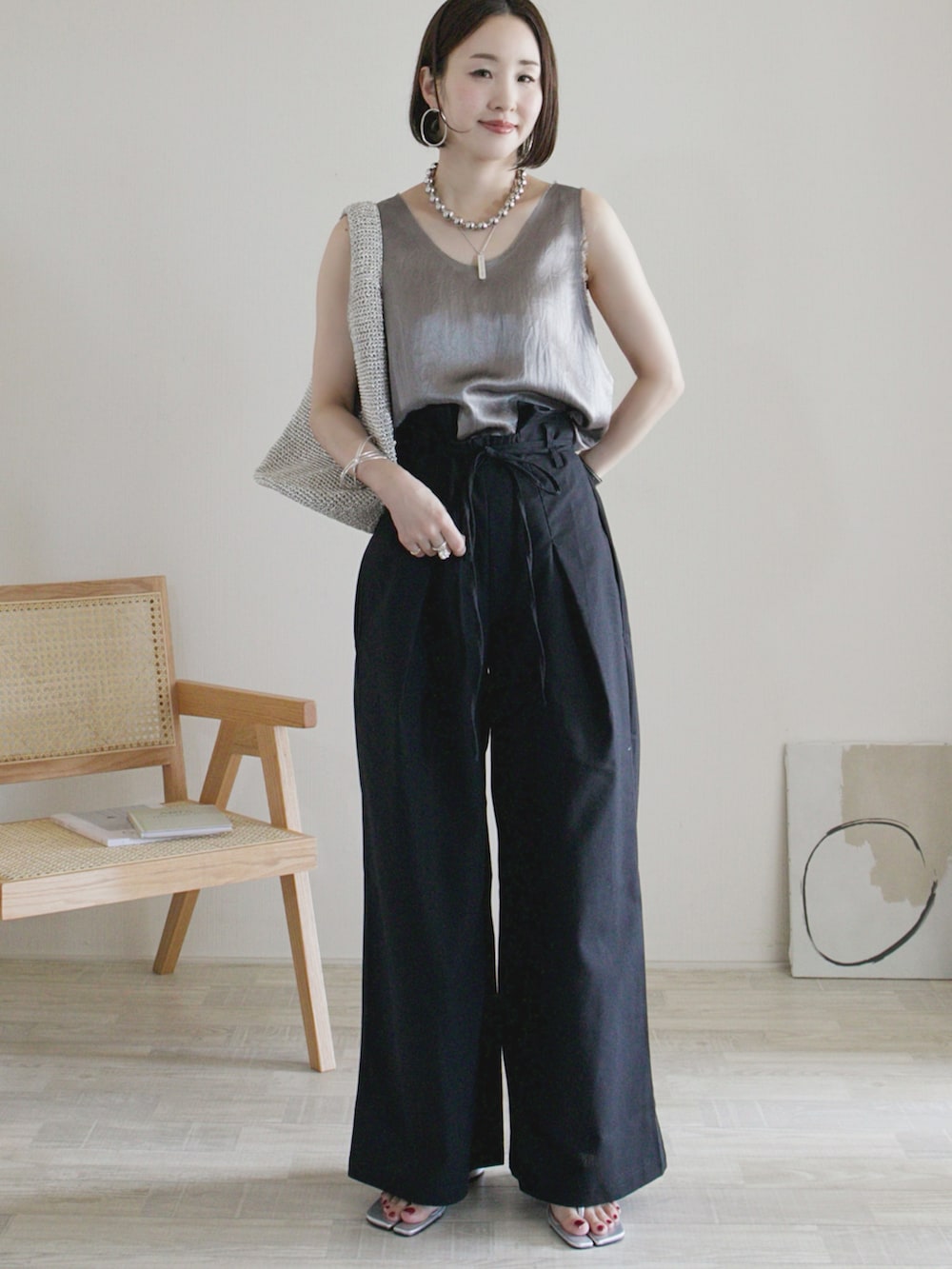 ブラック系のその他パンツ、グレー系のシャツ/ブラウス、シルバー系のサンダルを着用したレディースの夏コーディネートの2枚目の写真