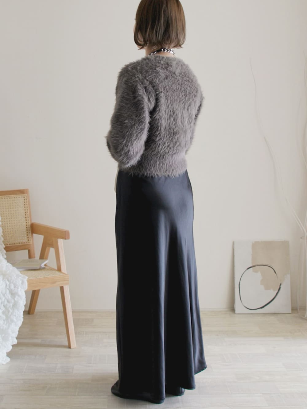 グレー系のニット/セーター、ブラック系のスカート、ブラック系のバレエシューズを着用したレディースの秋コーディネートの3枚目の写真