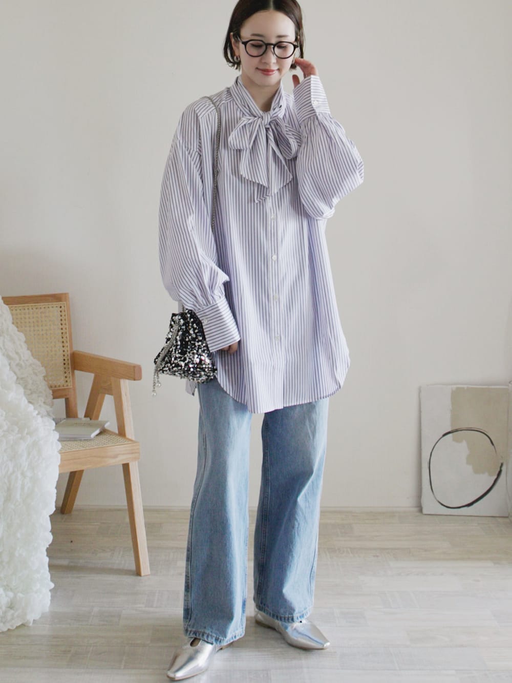 ホワイト系のシャツ/ブラウス、ブルー系のデニムパンツ、シルバー系のパンプスを着用したレディースの春コーディネートの2枚目の写真