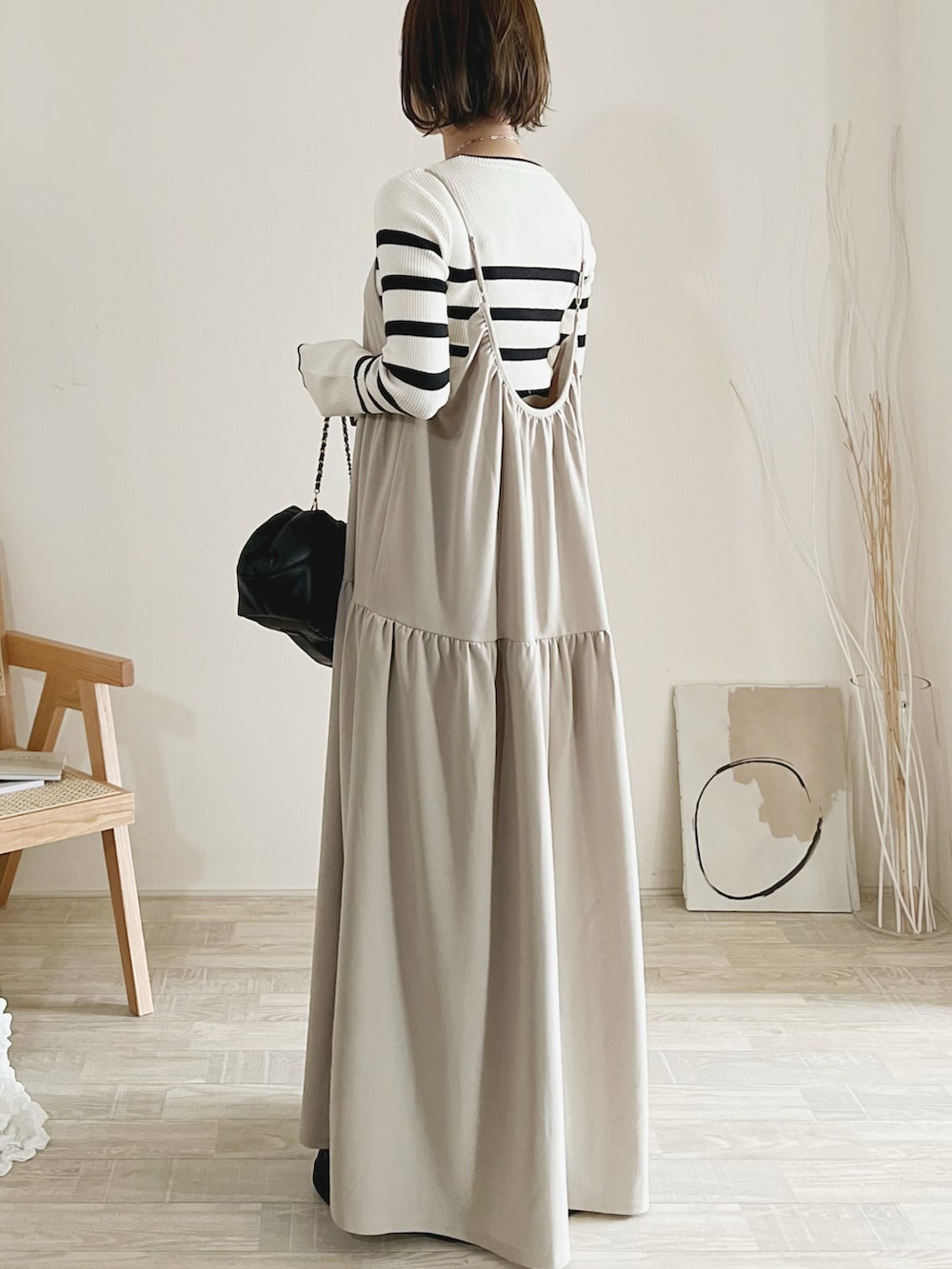 ホワイト系のニット/セーター、ベージュ系のジャンパースカート、ブラック系のブーツを着用したレディースの秋コーディネートの3枚目の写真