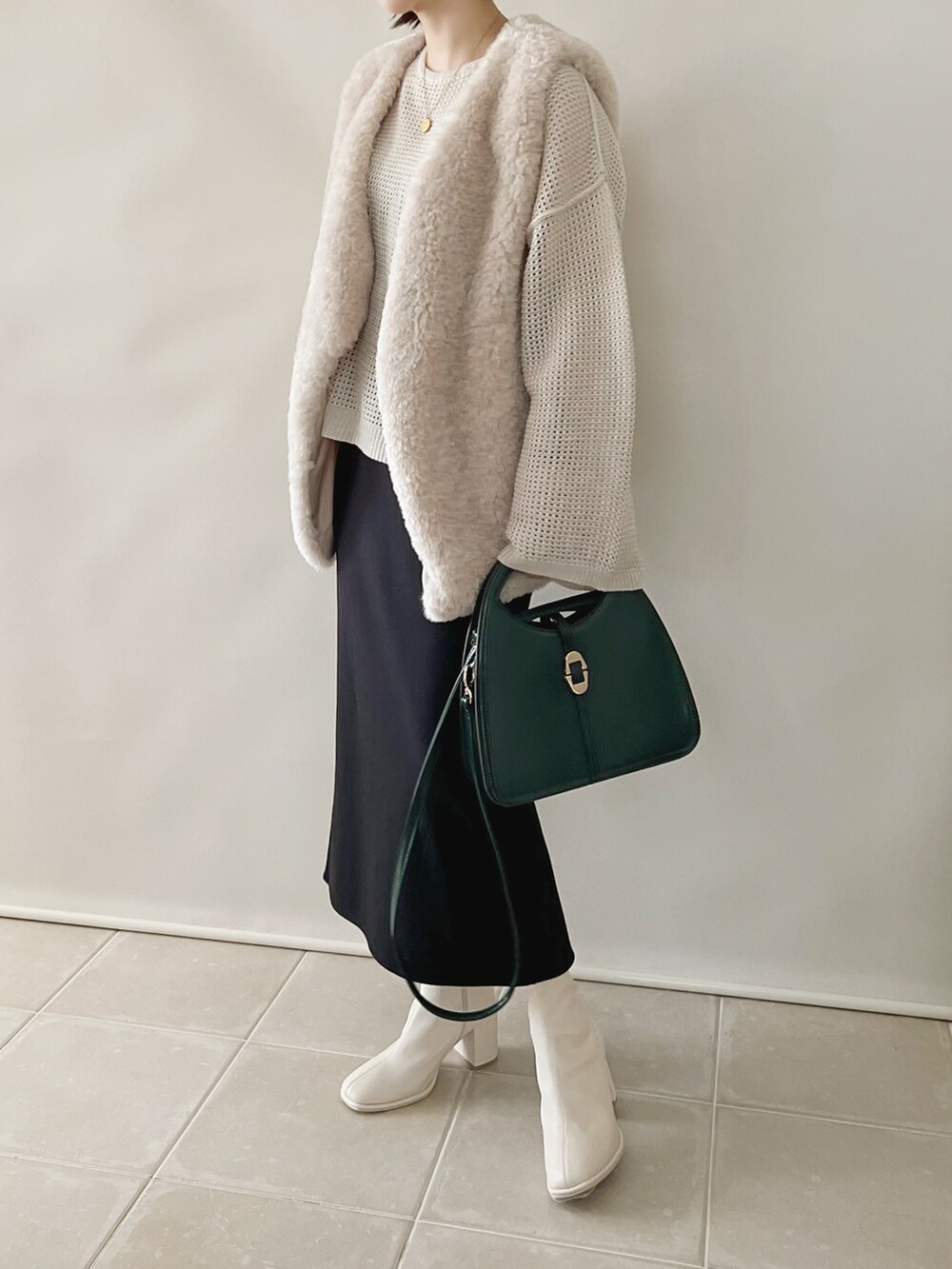 ベージュ系のトップス、ブラック系のスカート、ホワイト系のブーツを着用したレディースの秋コーディネートの3枚目の写真