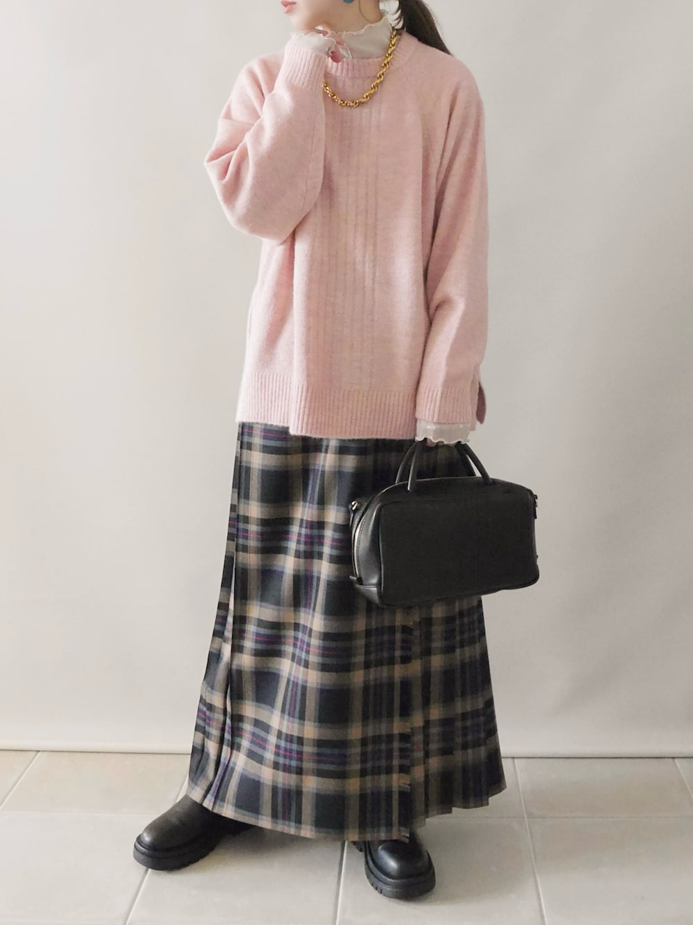 ピンク系のニット/セーター、ブラック系のその他パンツ、ブラック系のボストンバッグを着用したレディースの冬コーディネートの3枚目の写真