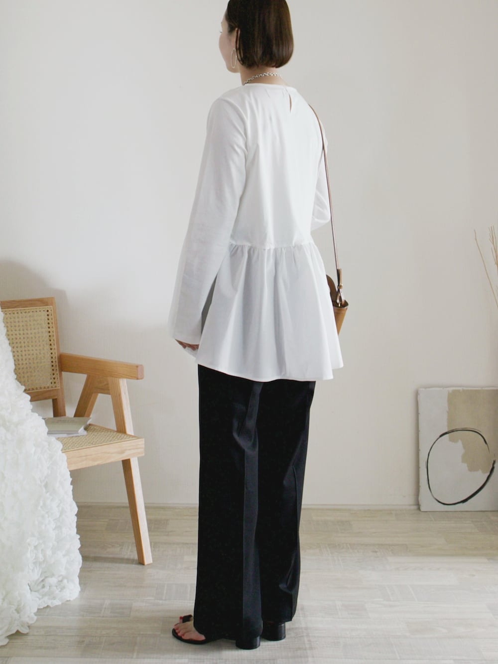 ホワイト系のTシャツ/カットソー、ブラック系のその他パンツ、ベージュ系のショルダーバッグを着用したレディースの春コーディネートの2枚目の写真