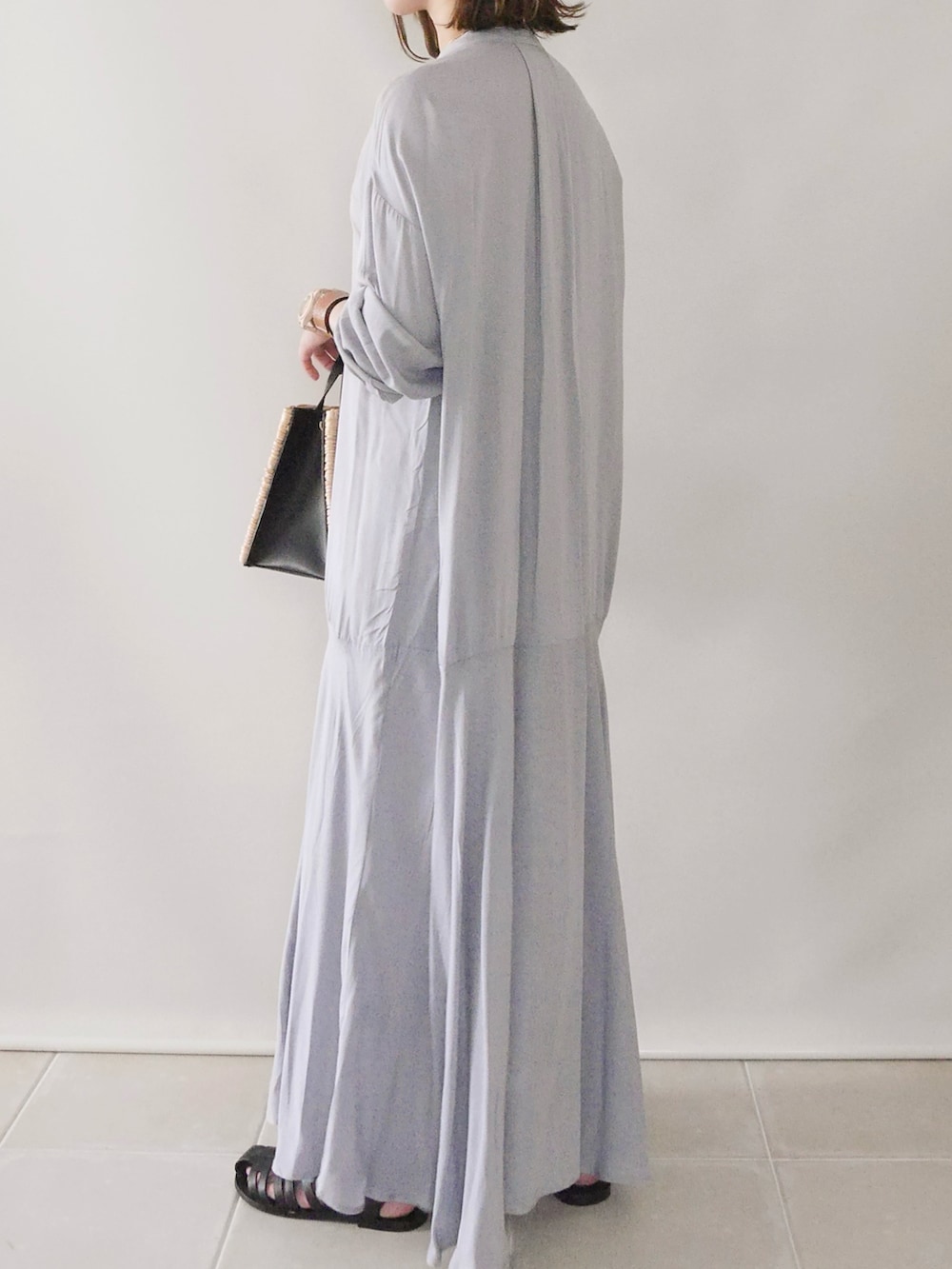 グレー系のシャツワンピース、ホワイト系のトップス、ブラック系のバッグを着用したレディースの春コーディネートの5枚目の写真