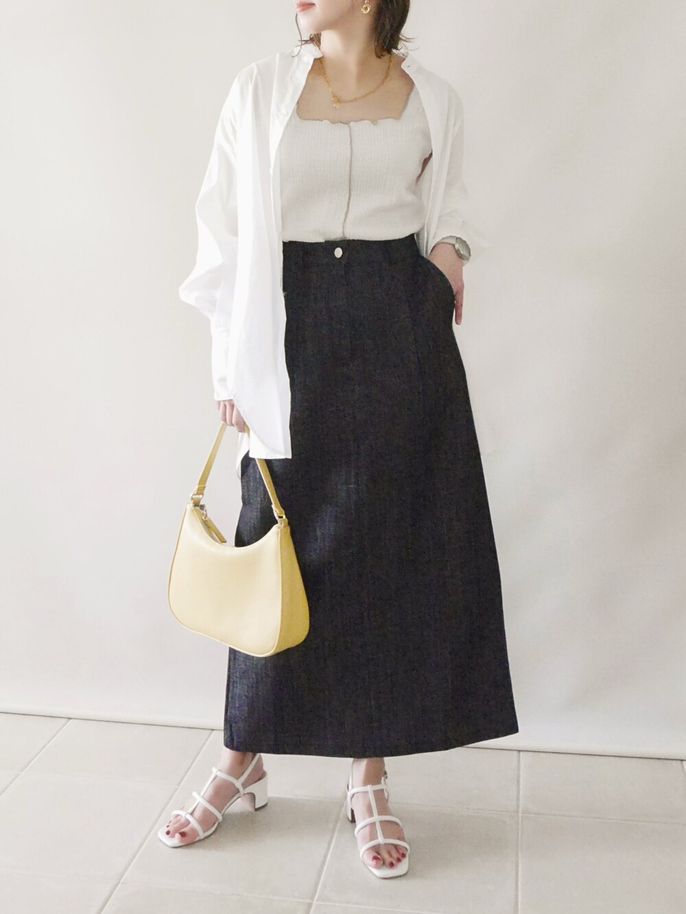 ホワイト系のサンダル、ブルー系のスカート、ベージュ系のタンクトップを着用したレディースの春コーディネートの2枚目の写真