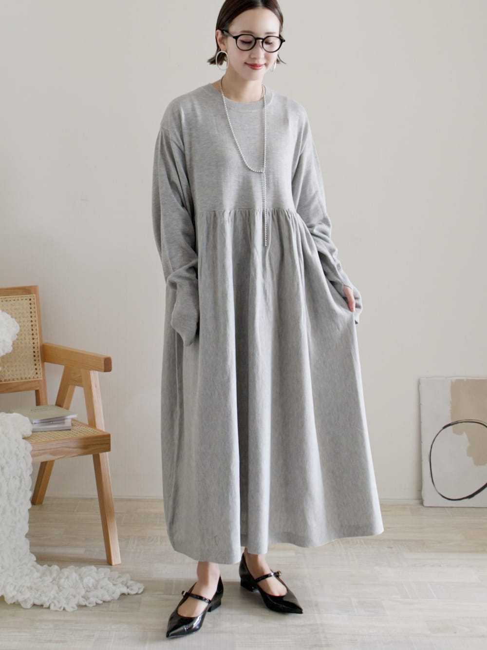 グレー系のワンピース、ホワイト系のパンプス、シルバー系のバングル/リストバンドを着用したレディースの冬コーディネートの3枚目の写真
