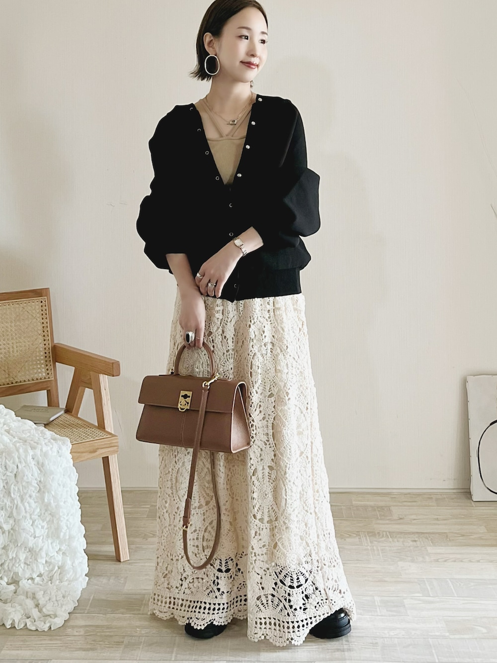 ブラック系のカーディガン/ボレロ、ホワイト系のトップス、ホワイト系のスカートを着用したレディースの秋コーディネートの2枚目の写真