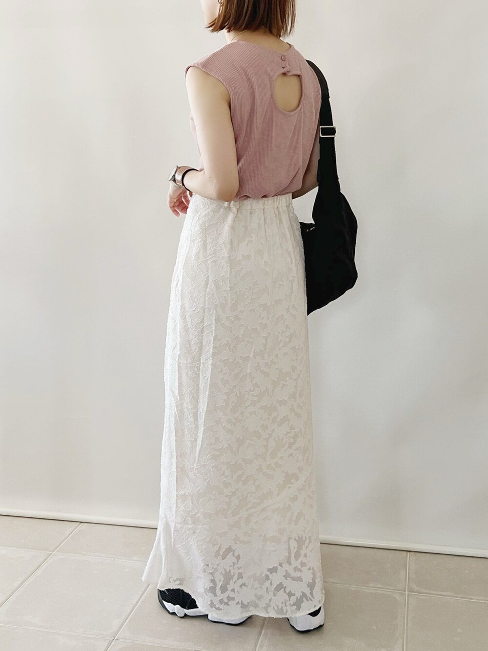 ピンク系のTシャツ/カットソー、ホワイト系のスカート、ブラック系のショルダーバッグを着用したレディースの夏コーディネートの2枚目の写真