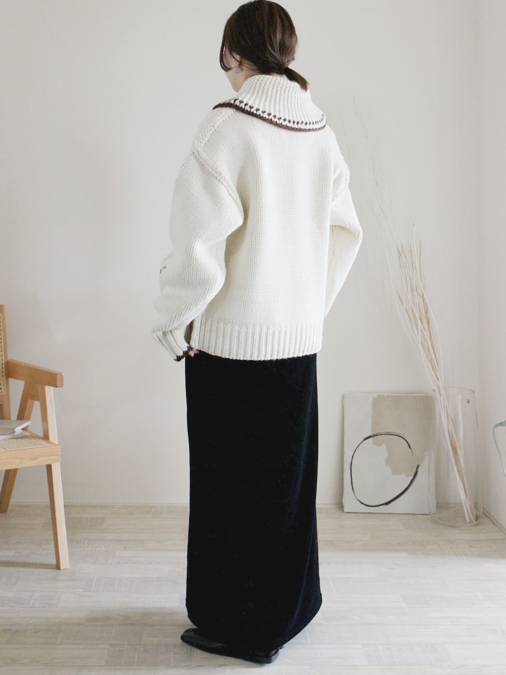 ホワイト系のブルゾン、ブラック系のスカート、ブラック系のバレエシューズを着用したレディースの冬コーディネートの2枚目の写真