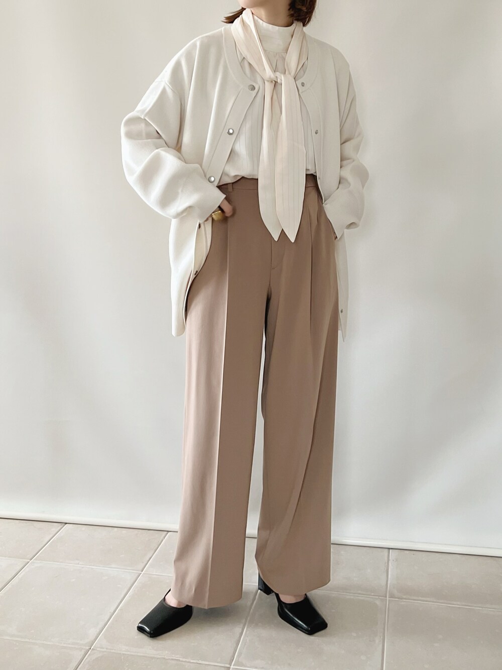 ホワイト系のシャツ/ブラウス、ベージュ系のパンツ、ブラック系のパンプスを着用したレディースの夏コーディネートの3枚目の写真