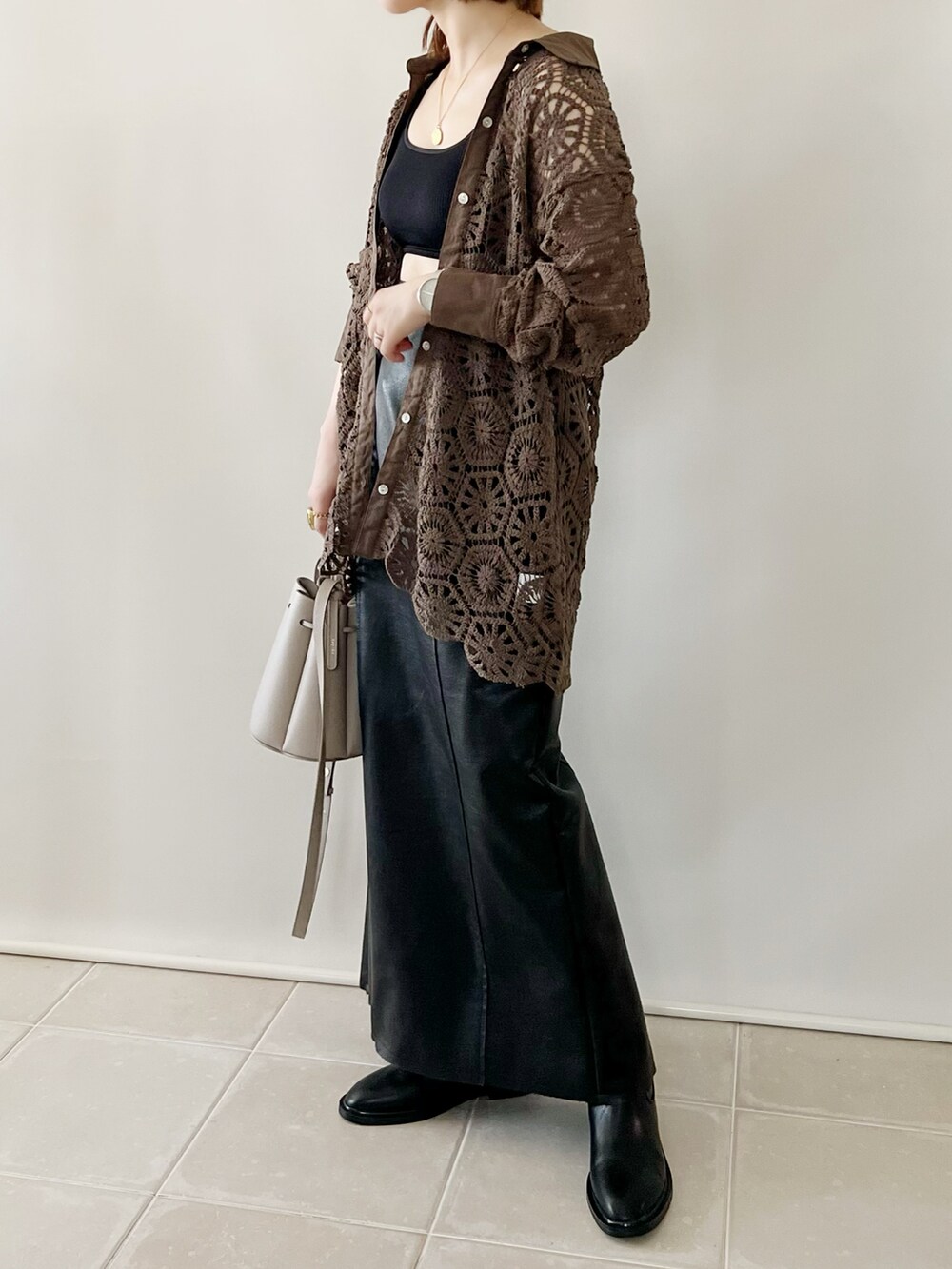 ブラウン系のトップス、ブラック系のスカート、グレー系のバッグを着用したレディースの夏コーディネートの2枚目の写真