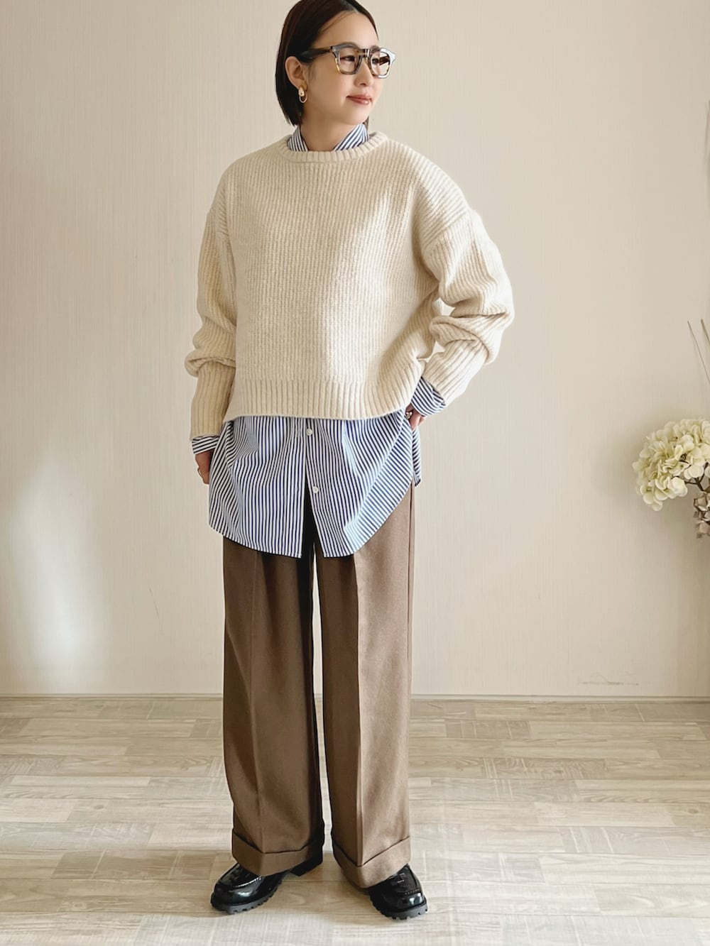 ホワイト系のニット/セーター、ブルー系のシャツ/ブラウス、ブラウン系のパンツを着用したレディースの冬コーディネートの2枚目の写真