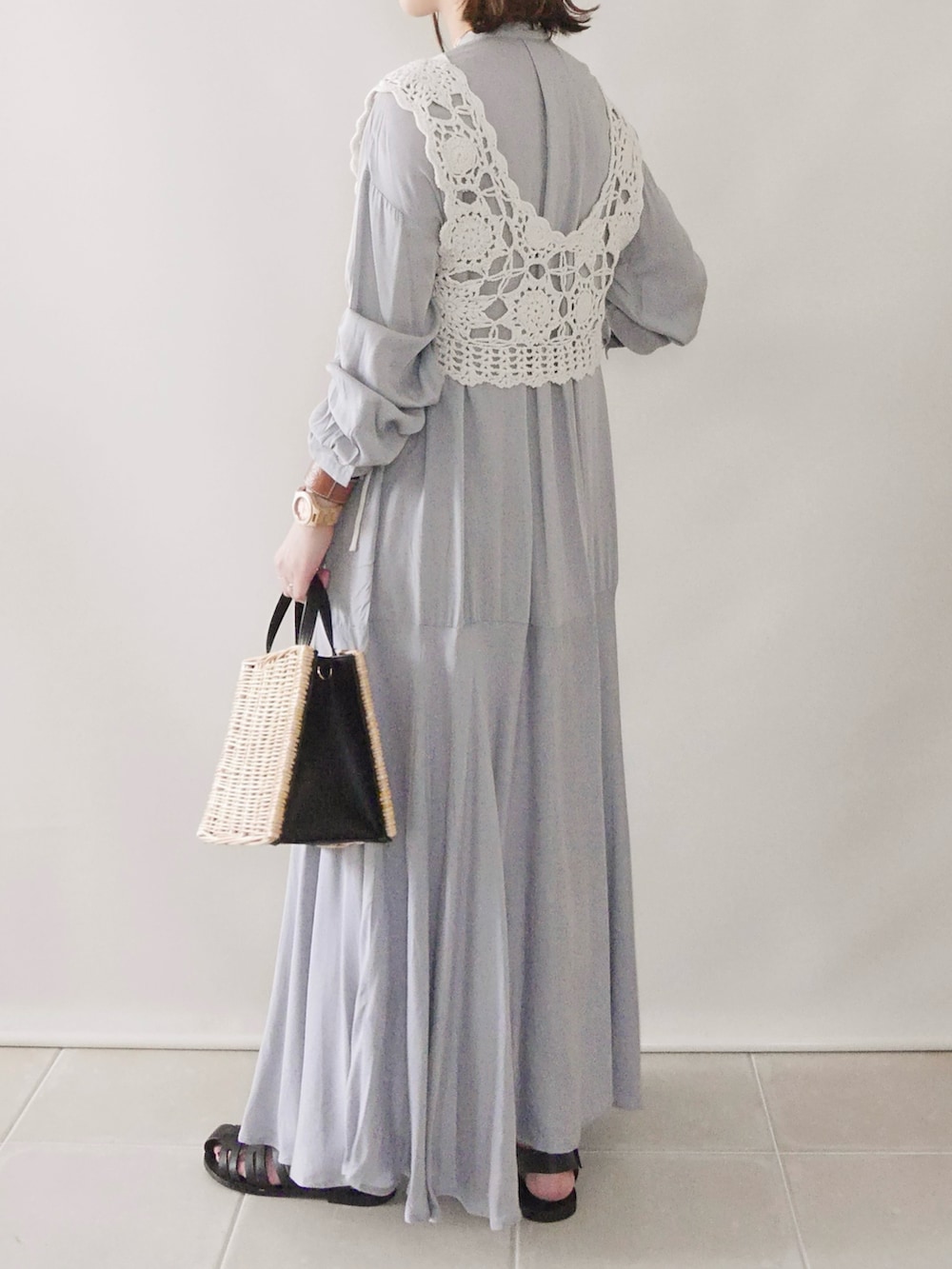 グレー系のシャツワンピース、ホワイト系のトップス、ブラック系のバッグを着用したレディースの春コーディネートの3枚目の写真