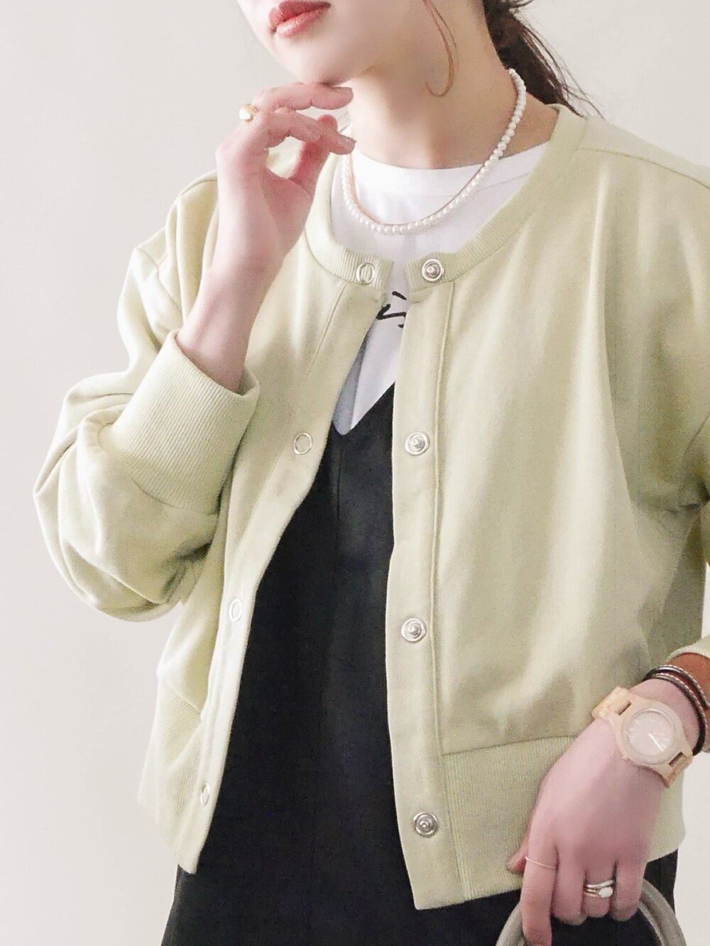 グリーン系のカーディガン/ボレロ、ブラック系のジャンパースカート、ブラウン系の口紅/リップティント/グロスを着用したレディースの冬コーディネートの2枚目の写真