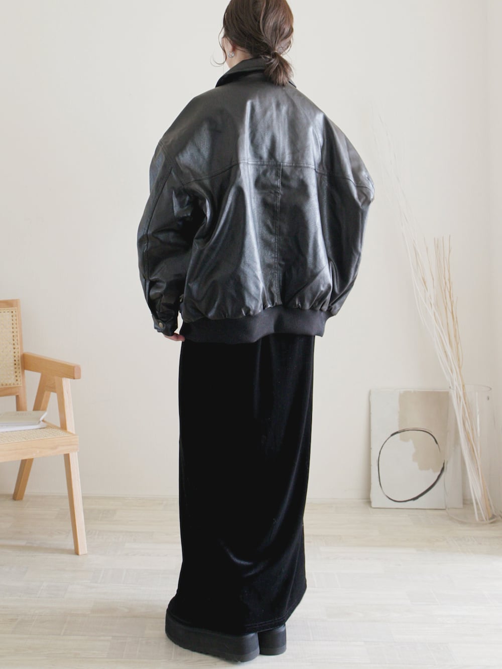 ブラック系のスカート、ブラック系のブルゾン、ブラック系のブーツを着用したレディースの冬コーディネートの2枚目の写真