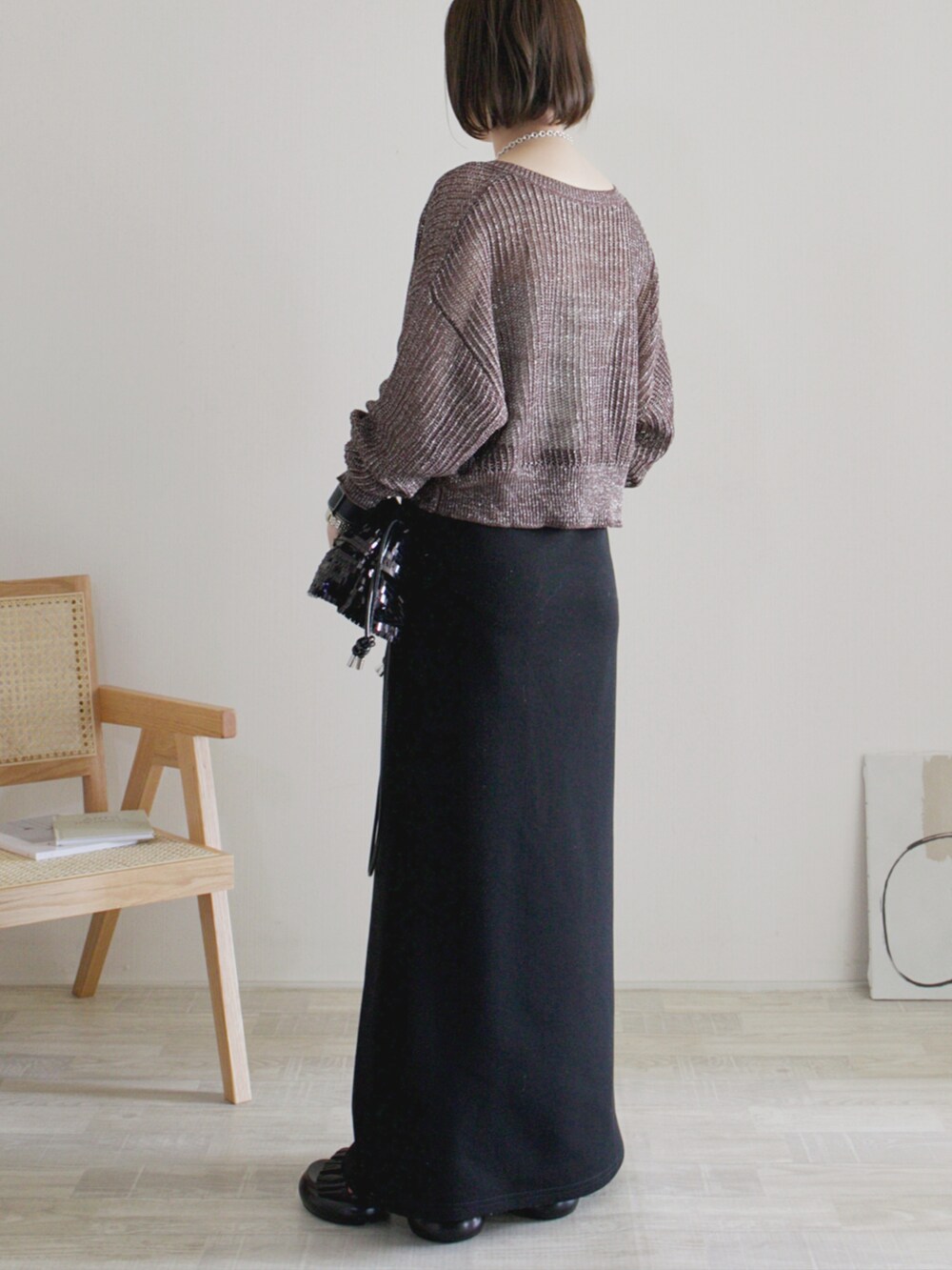 ブラウン系のカーディガン/ボレロ、ベージュ系のキャミソール、ブラック系のスカートを着用したレディースの夏コーディネートの2枚目の写真